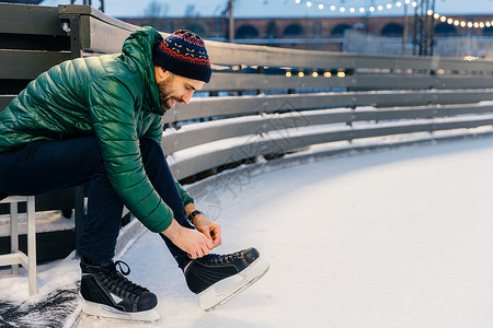 快乐的男鞋带滑冰在环上练习心情好像冬天一样和最好的朋友滑冰图片