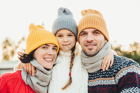 美丽的妇女穿着温暖围巾和毛衣与丈夫女儿一起享受自由时间图片