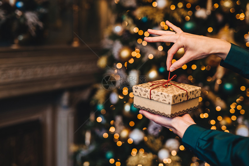 女将新的一年礼物包裹在客厅里靠近美丽的装饰fir树节日xmas和庆祝概念图片