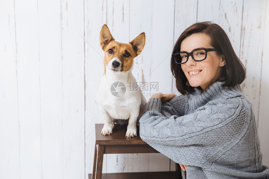 年轻女人站在她最喜欢的狗旁边图片