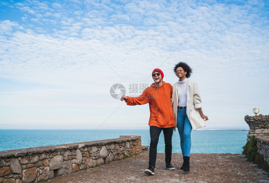 两位年轻朋友一起度过美好时光在海岸线上行走玩得开心图片