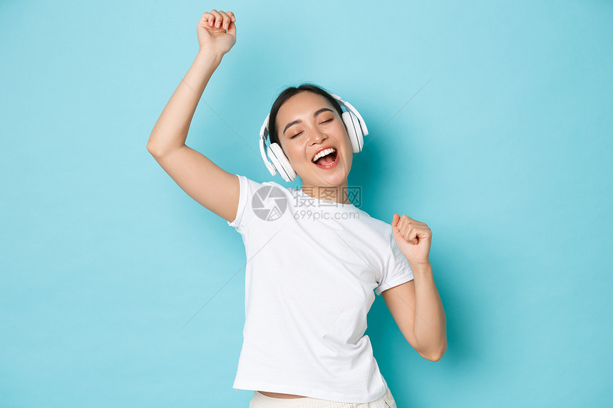 购物金钱和融概念欢快的亚洲女孩穿白色散装t恤唱卡拉ok播放音乐应用程序听无线耳机音乐并享受完美的声音购物播放音乐应用听无线耳机音图片