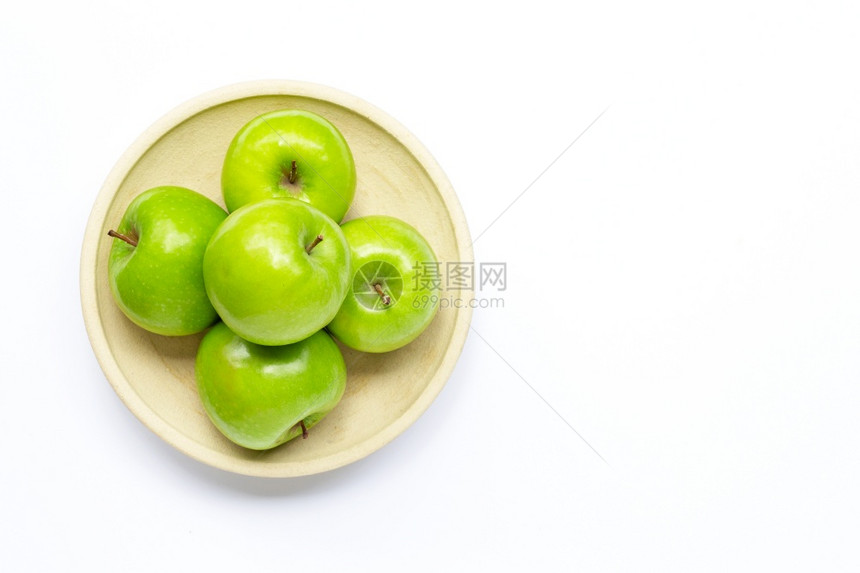 白色背景的陶瓷板上新鲜绿苹果复制空间图片
