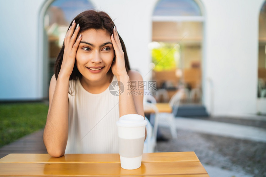 年轻拉丁裔女在咖啡店喝图片