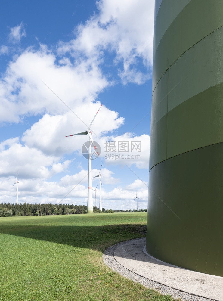 在阳光明媚的夏日以绿草蓝天和白云为绿草用德国菜叶中的风涡轮机图片