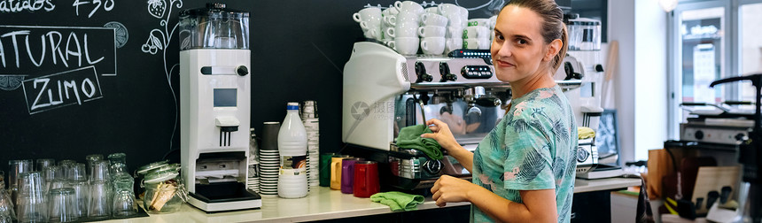 服务员笑着清洁咖啡机图片