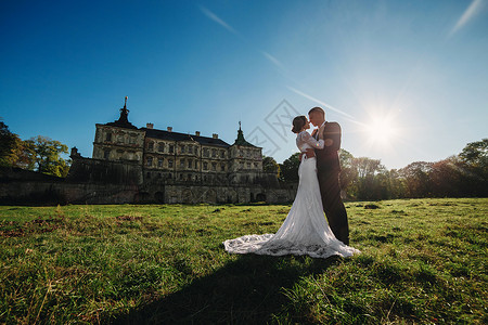 在城堡旁的草地上拍婚纱照的夫妻图片