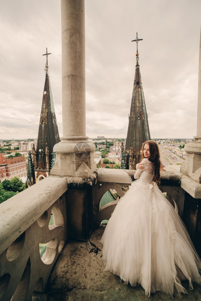 身着豪华礼服的美丽新娘站在大阳台上图片