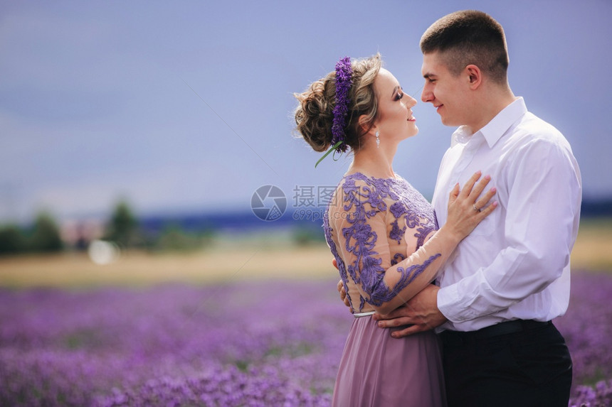 一对年轻夫妇在熏衣草地上行走一对穿着豪华紫色裙子的女孩一对美丽的夫妇在花草地上行走一对美丽的夫妇在花草地上行走图片