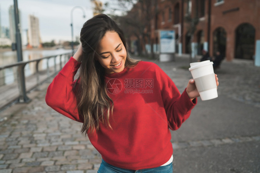 美丽的年轻女子在户外喝咖啡的肖像城市概念图片