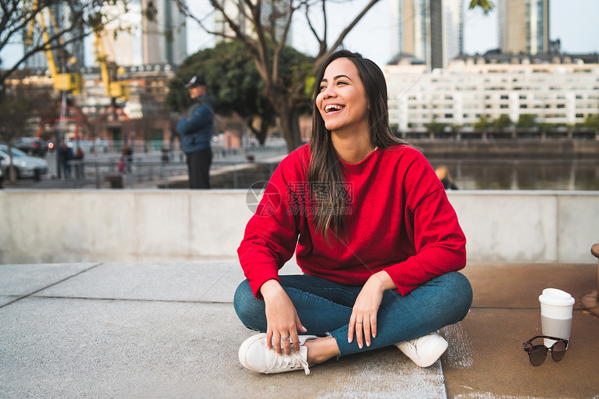 坐在户外喝着咖啡的拉丁女青年肖像城市概念图片