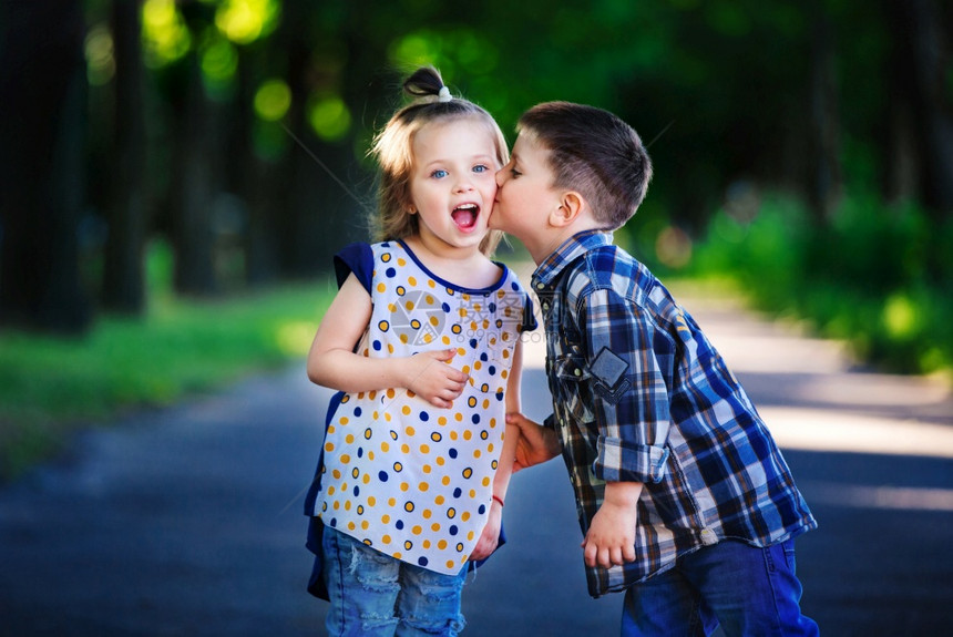 小男孩和女孩在户外亲吻图片