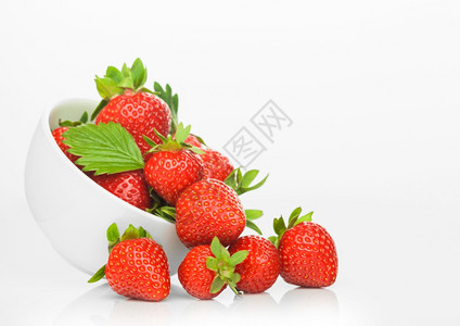 白色陶瓷碗盘中的新鲜生有机草莓白色背景边有浆果图片