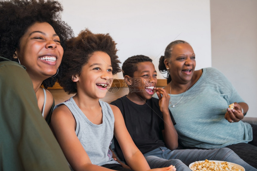 祖母亲和孩子在看电影坐沙发上吃爆米花图片