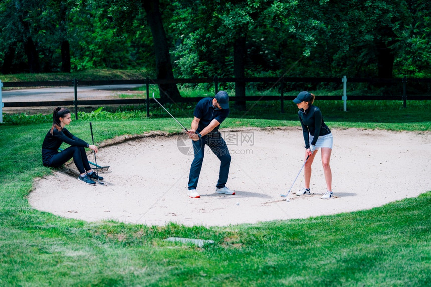 年轻女子与高尔夫教练习图片