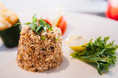 Thai辣炒米饭白盘上加蔬菜和香肠图片