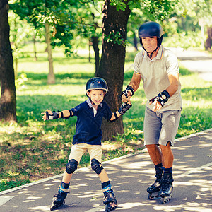 学习滑冰爷和孙子在公园玩滑溜背景