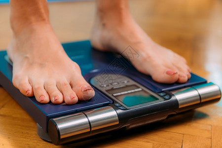 使用身体组成监测器量妇女体重脂肪图片