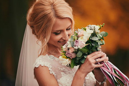新娘在婚礼当天闻着花束图片