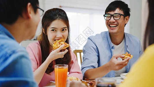 吐司披萨asi家庭聚会吃披萨欢笑饭坐在餐厅桌旁庆祝节假日和聚会背景