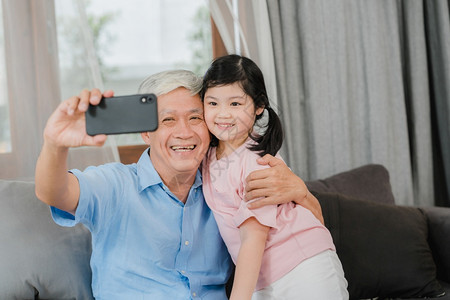爷和年轻女孩使用手机视频电话和她爸妈聊天图片