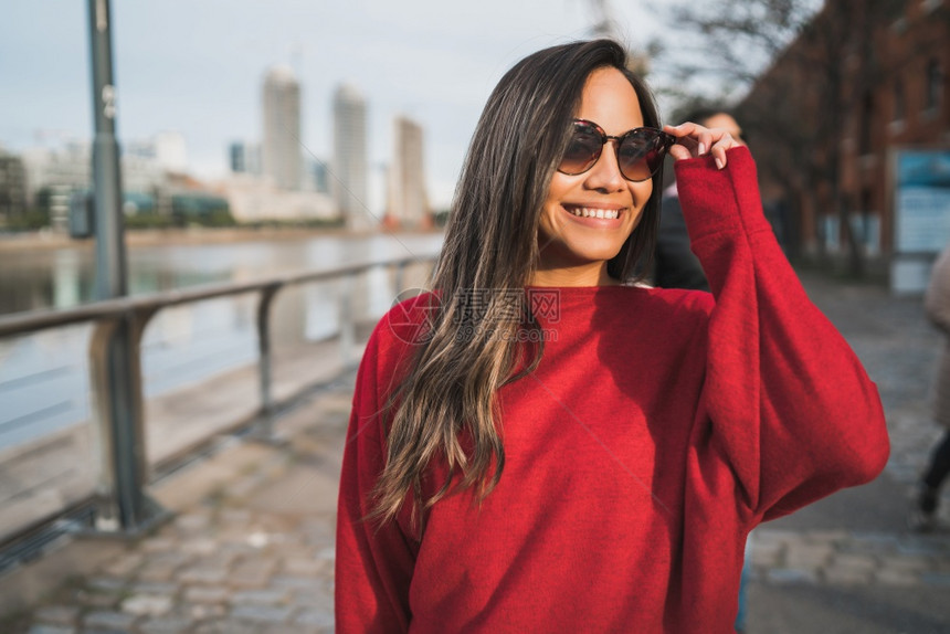 年轻拉丁女人在街上外戴太阳镜的肖像城市概念图片
