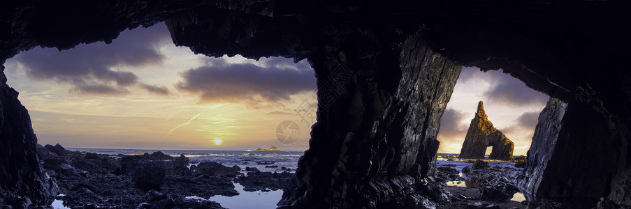 山雀岩石海岸沙滩上的洞穴全景日落时分阿斯图里亚西班牙背景图片