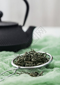 s训练员用松散的绿色有机茶在布上喷洒图片