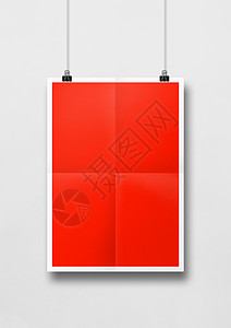 挂在白墙上贴有剪片的红色折叠海报空白模型板挂在白墙上贴有剪片的红色折叠海报背景图片