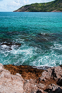 绿宝石蓝色海浪和边的岩石岸位于普吉的亚努伊海滩背景图片