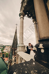 在哥特教堂阳台上接吻的夫妇图片
