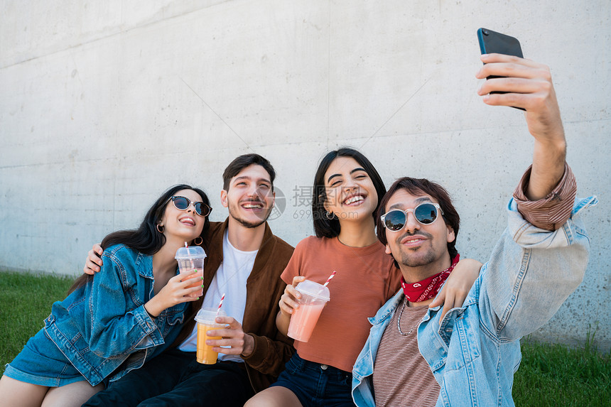 一群朋友起玩得开心同时用手机拍自生活方式和友谊概念图片