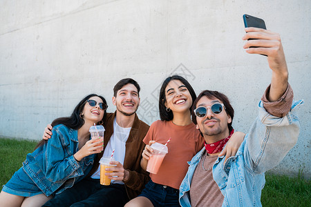 一群朋友起玩得开心同时用手机拍自生活方式和友谊概念图片
