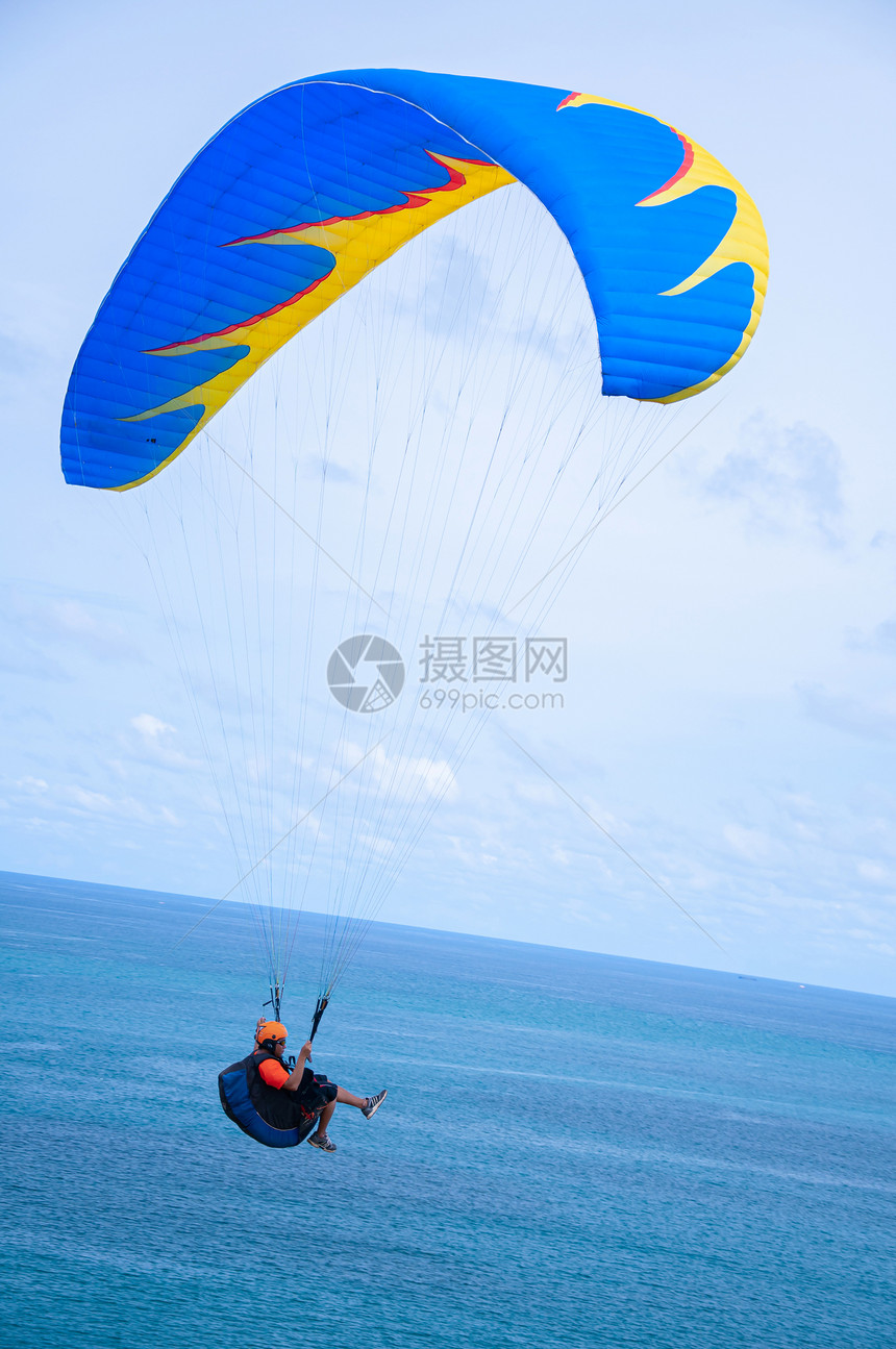 旅游者享受滑翔运动在蓝海上空高飞图片
