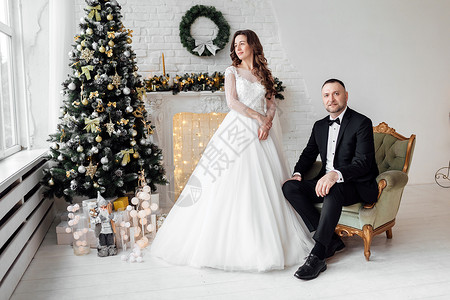 新婚夫妻在圣诞树旁拍婚纱照图片