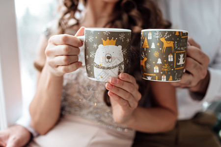 男人和女手拿着圣诞装饰杯喝着热咖啡或茶圣诞节爱家庭图片