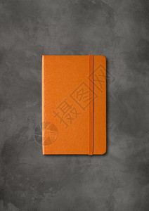 橙色封闭笔记本模型在暗混凝土背景上隔离橙色封闭笔记本在暗混凝土背景上隔离背景图片