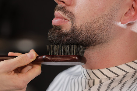 理发师在店长和梳客户的胡子理发师在店为男子制造型和理店长胡子有选择地集中注意力理发师在店长和胡子理师在店长和胡子有选择地集中注意背景图片