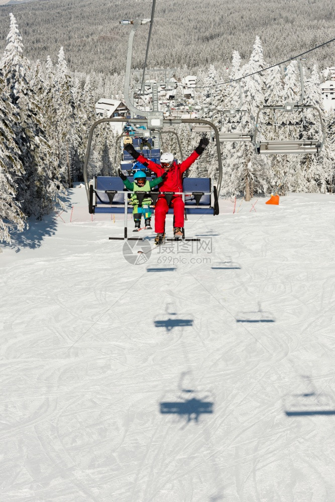 教练带小男孩享受滑雪索道图片