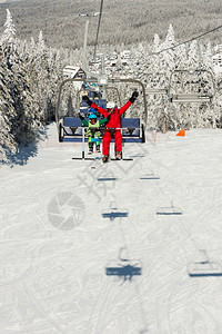 教练带小男孩享受滑雪索道图片