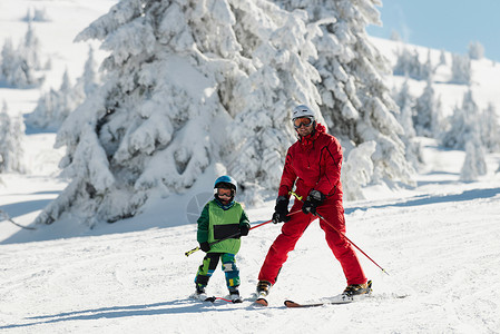 教练带小男孩滑雪高清图片