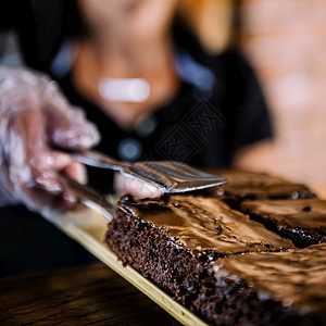 女店员穿着黑色制服在面包店卖巧克力蛋糕图片