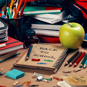 作文雇主回收纸笔记本彩色铅绿苹果书籍磨刀红墨水和蓝色橡皮纸回到学校概念背景