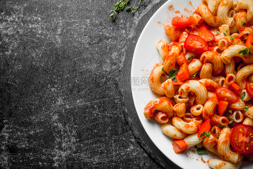盘子上有番茄的意大利面生锈背景的意大利面图片