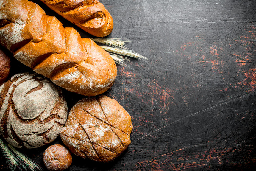 不同种类的面包在生锈背景上不同种类的不同的面包图片