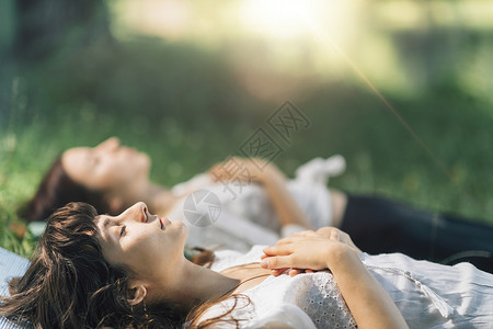 水的冥想两名年轻妇女躺在水边和冥想图片