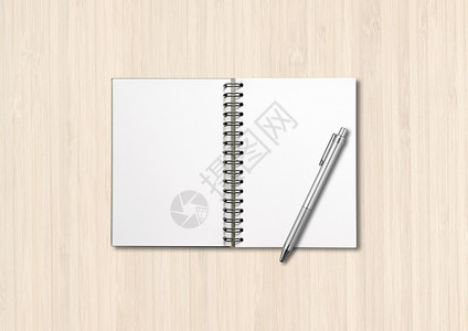 白木背景上隔离的空开螺旋笔记本和白木背景上隔离的笔图片