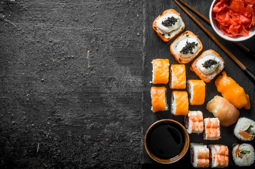 传统的日本寿司卷黑石板上加姜和酱油黑色生锈背景的石板上加姜和酱油传统的日本寿司卷黑石板上加姜和酱油图片