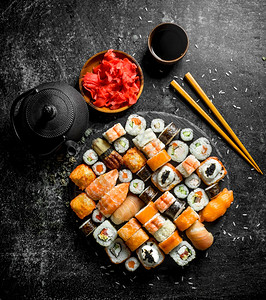 传统的日本寿司卷配有酱油和红黄姜含深色生锈背景配有酱油和红黄姜图片