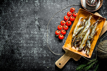 用西红柿和香料熏鱼深生背景的熏鱼图片